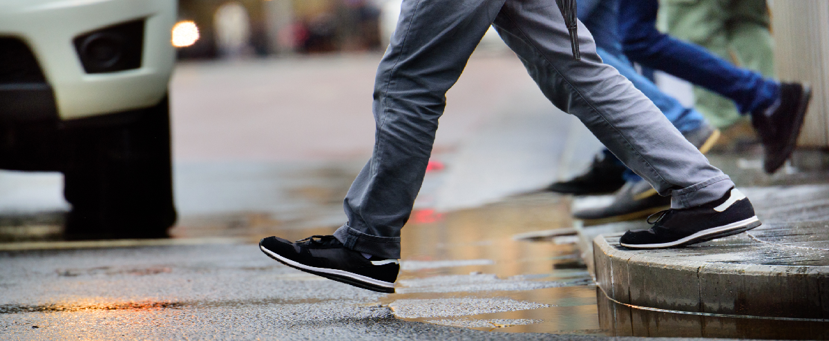 Pedestrian walking in front of a driving car