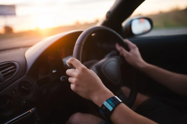 hands on steering wheel of car