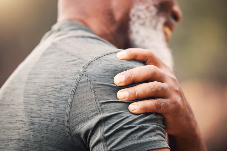 man grabs injured shoulder